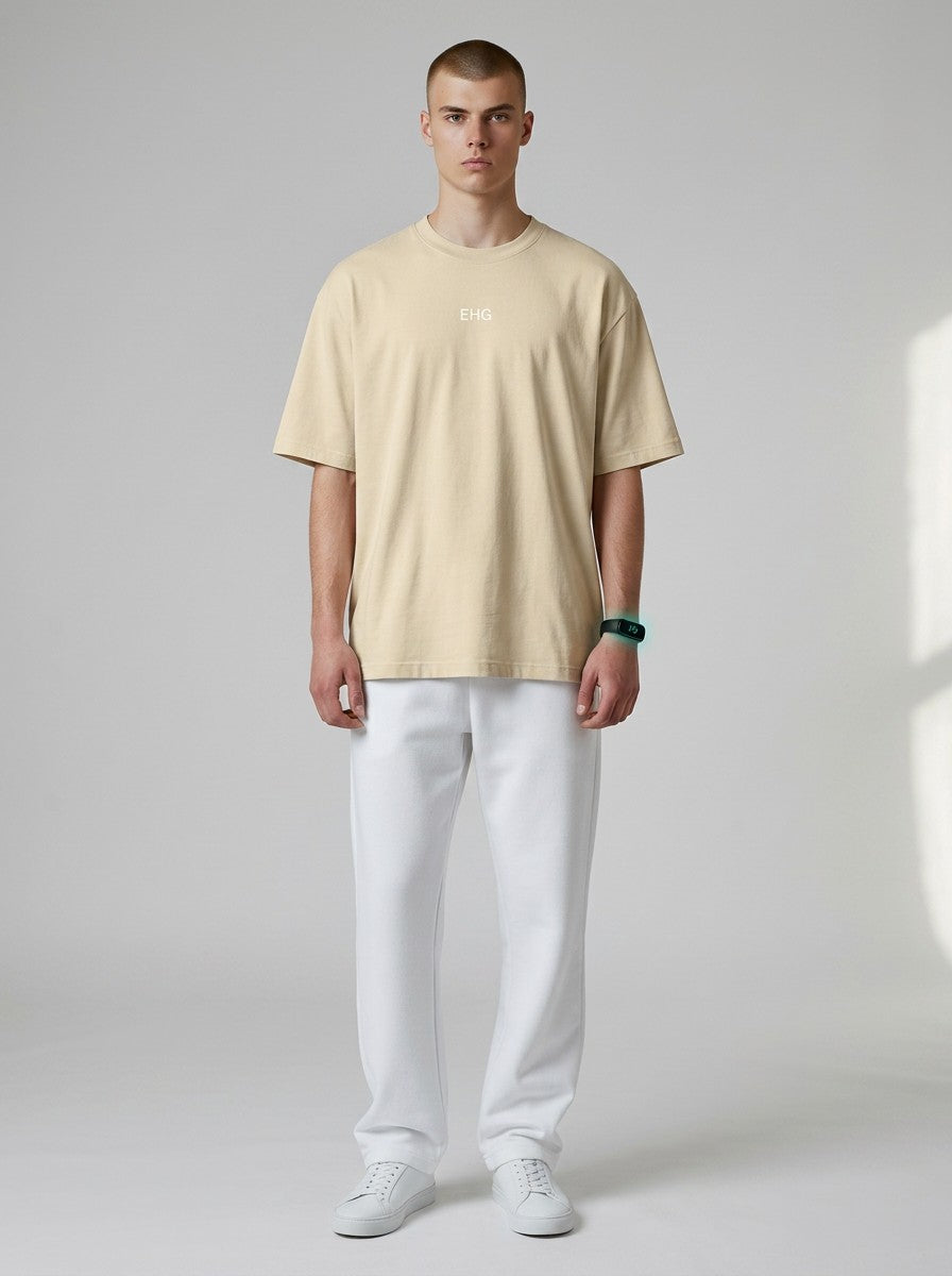 Model wearing an EHG SmartWellness heavyweight beige cotton t-shirt with a round neck and white trousers.