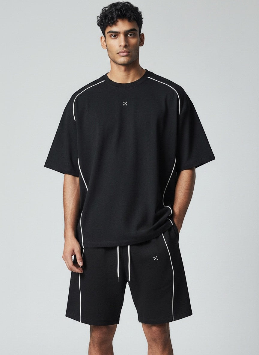 Model wearing EHG SmartWellness black cotton drawstring shorts with white piping detail and a matching t-shirt.