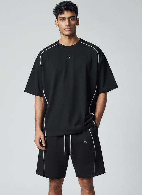 Model wearing EHG SmartWellness black cotton drawstring shorts with white piping detail and a matching t-shirt.