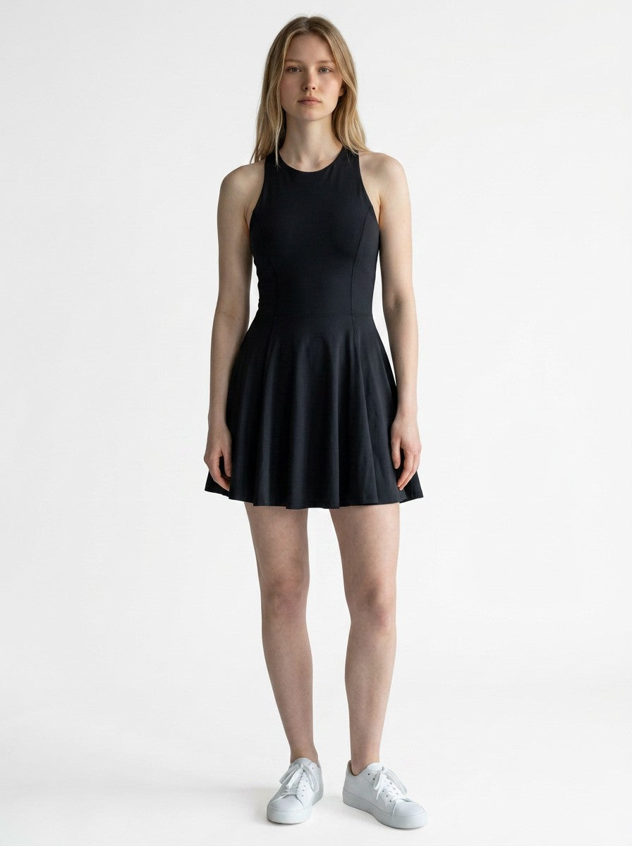 Model wearing an EHG SmartWellness black sleeveless athletic mini dress with a round neck and flared skirt