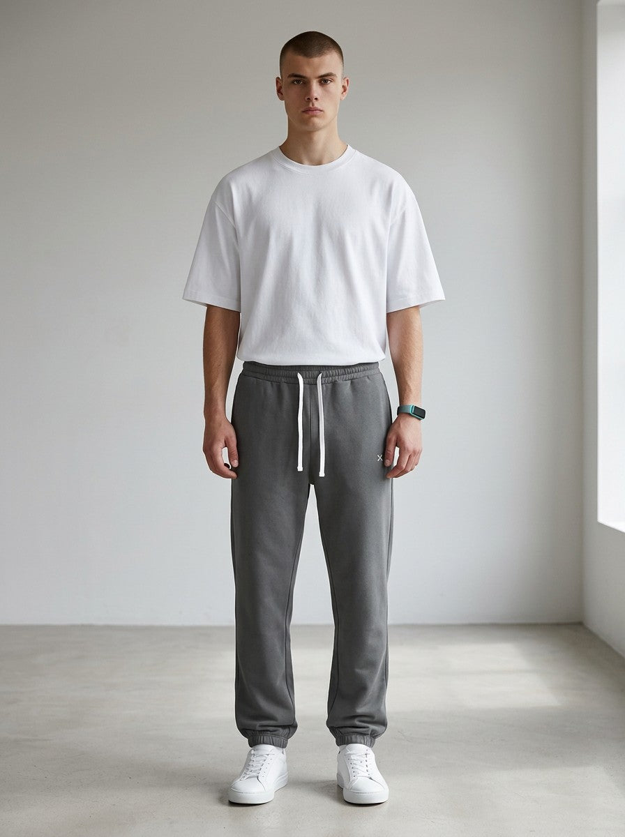 Model wearing EHG SmartWellness Essential Sweatpants in charcoal grey with a white drawstring and relaxed fit.
