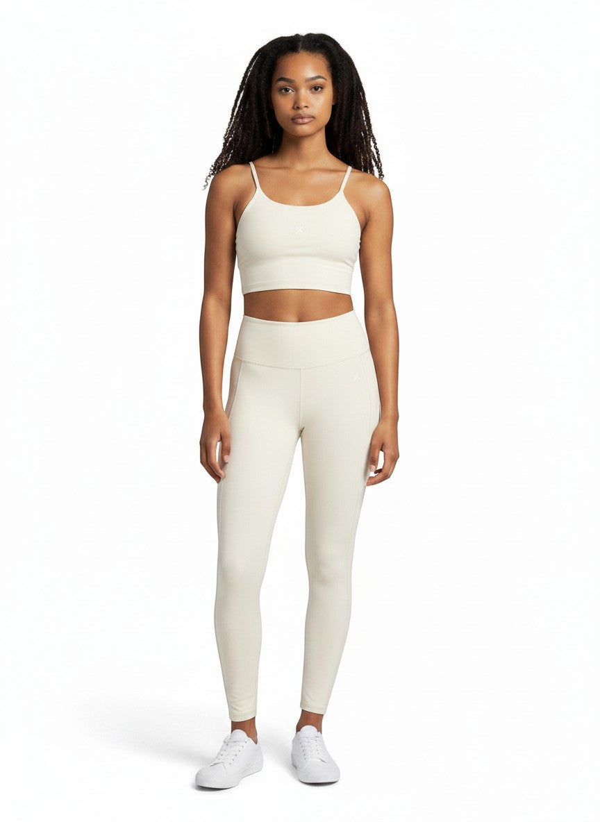 Model wearing EHG SmartWellness cream spaghetti strap sports bra and matching leggings for yoga or gym workouts.