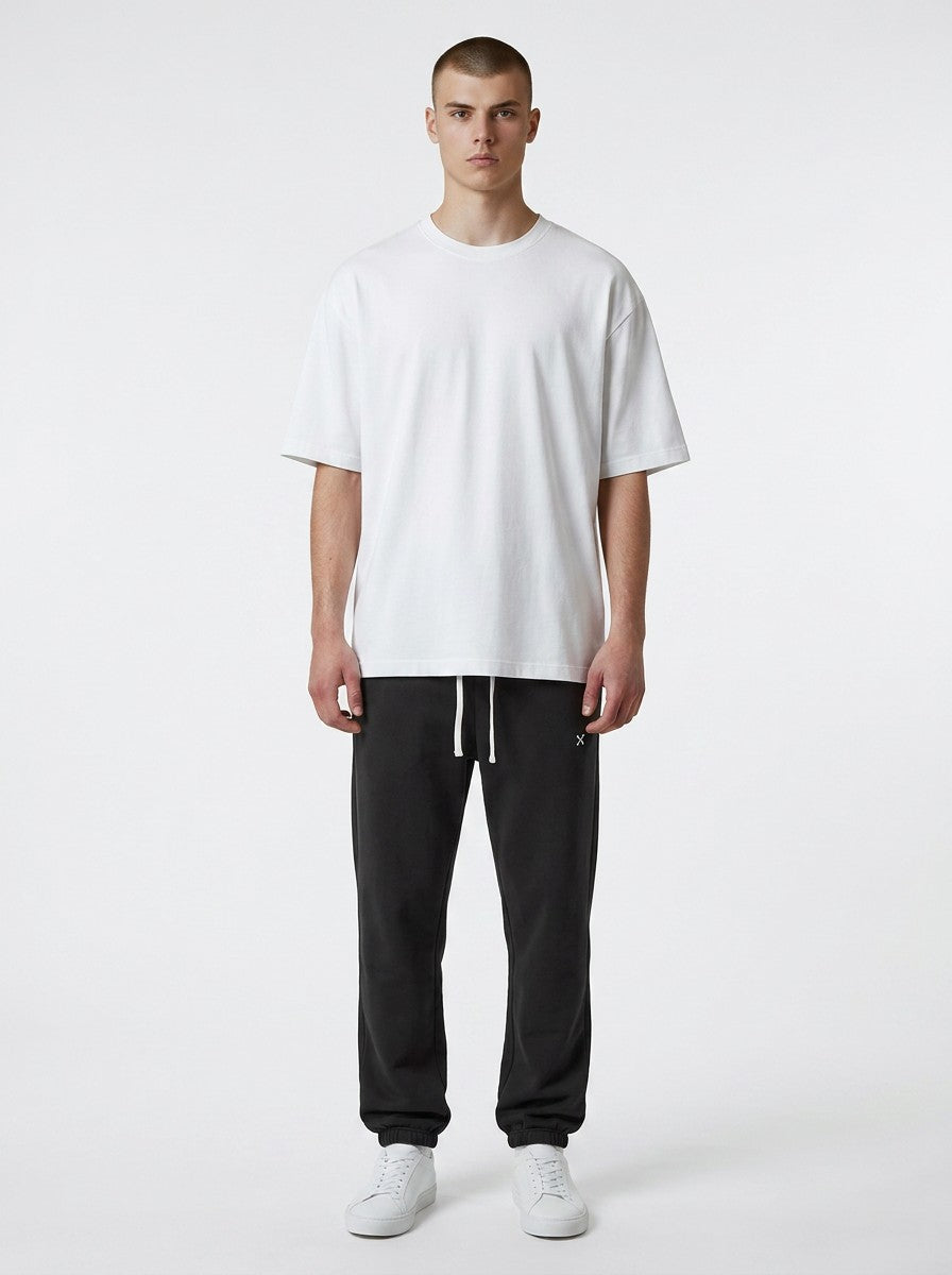 A model wearing EHG SmartWellness Essential Sweatpants in black with a drawstring waist and a white t-shirt.