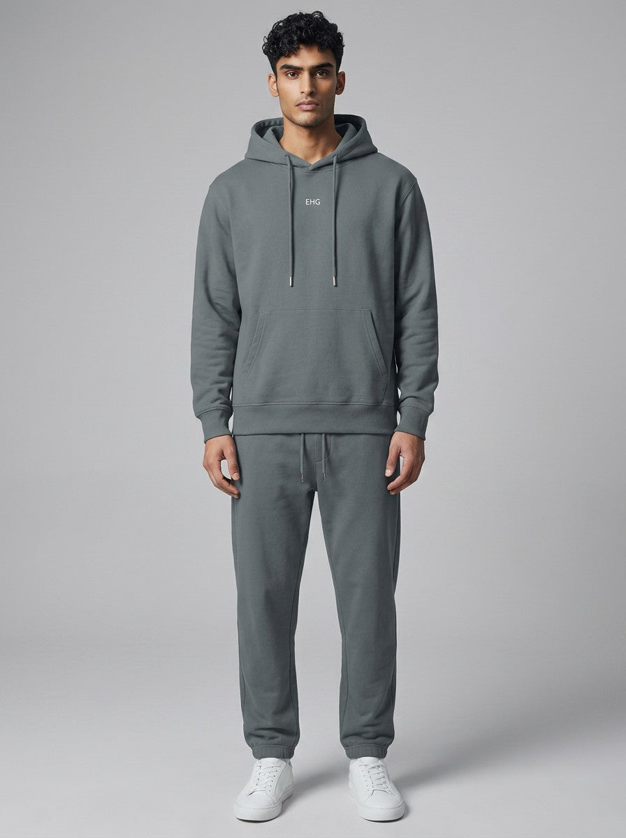 A man wearing an EHG SmartWellness grey cotton hoodie with a drop shoulder, relaxed fit, and front kangaroo pocket.