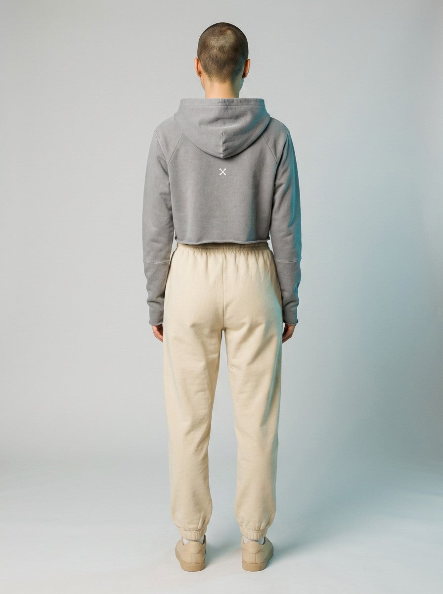 Back view of a model wearing an EHG SmartWellness grey vintage washed cropped hoodie with raw edges and cream joggers.