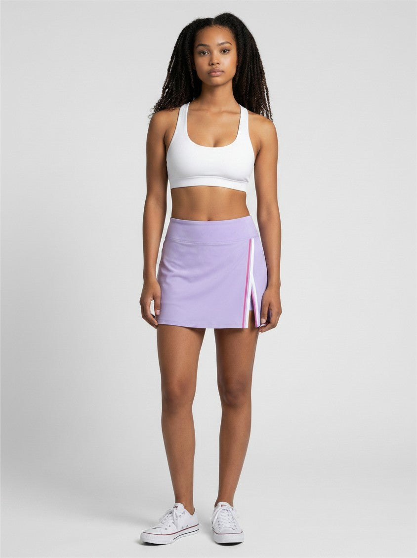 Model wearing EHG SmartWellness lavender A-line athletic skirt with contrast side panel and slit, paired with white top