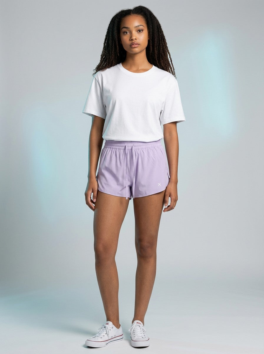 Model wearing EHG SmartWellness lavender Bermuda shorts with a drawstring waist and white t-shirt in a studio.