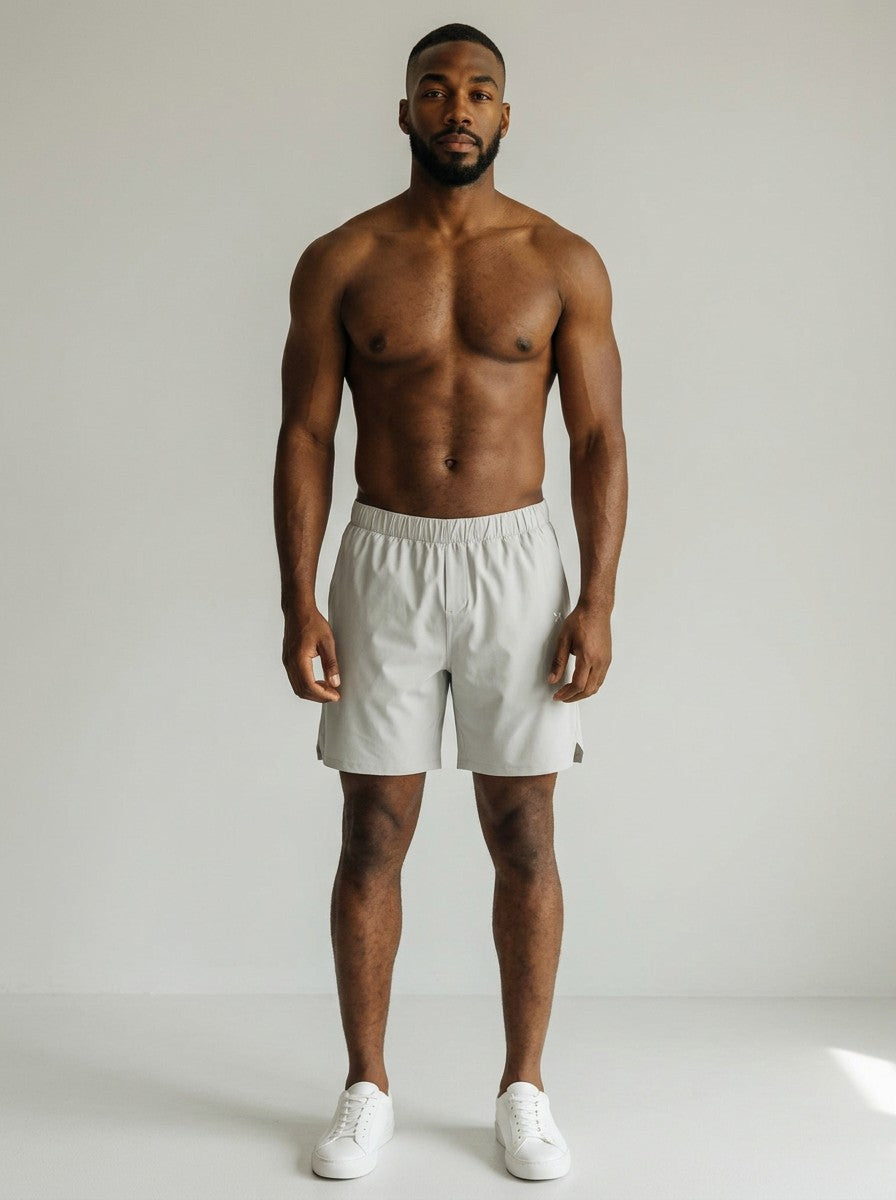 A fit man wearing light grey EHG SmartWellness performance shorts with a loose athletic fit and elastic waistband.