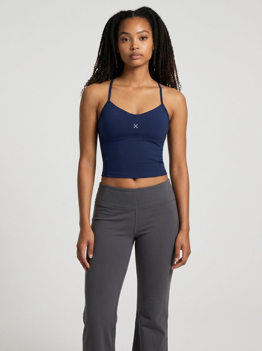 Model wearing a navy blue EHG SmartWellness cropped yoga sports top with thin straps and a minimalist design.