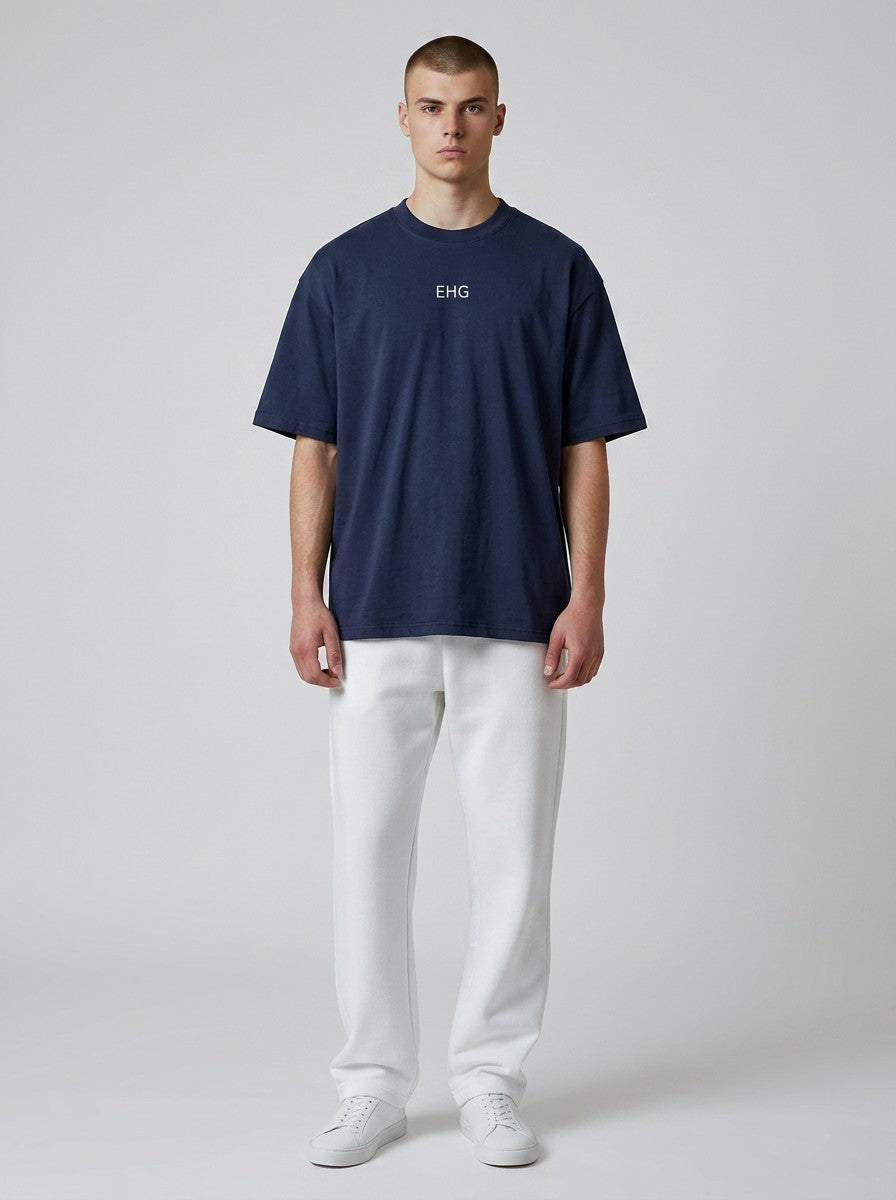 A model wearing an EHG SmartWellness navy blue heavyweight cotton t-shirt with a round neck and white trousers.