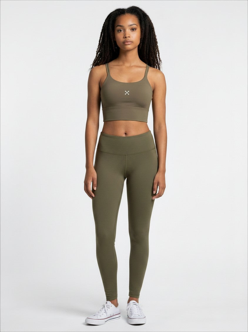EHG SmartWellness olive green spaghetti strap yoga sports bra worn by a model with matching leggings and white sneakers