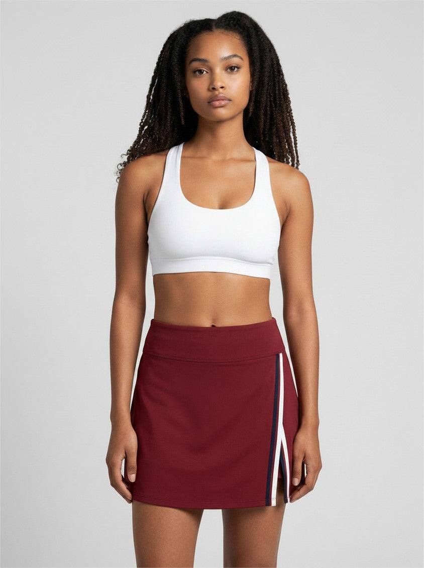 EHG SmartWellness A-line athletic skirt in deep red with contrast side panel and slit, worn by a model in a studio.