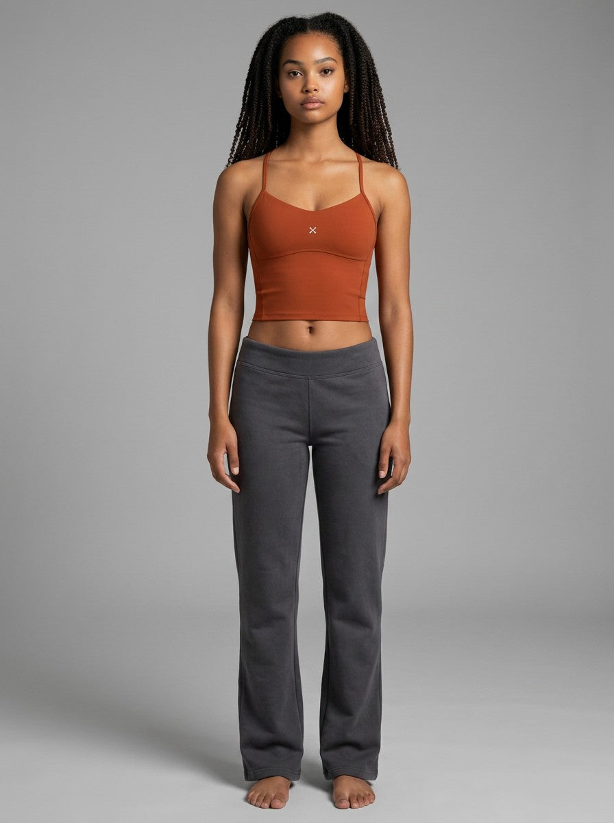 Model wearing EHG SmartWellness rust-coloured cropped sports tank top with thin straps and a minimalist design.
