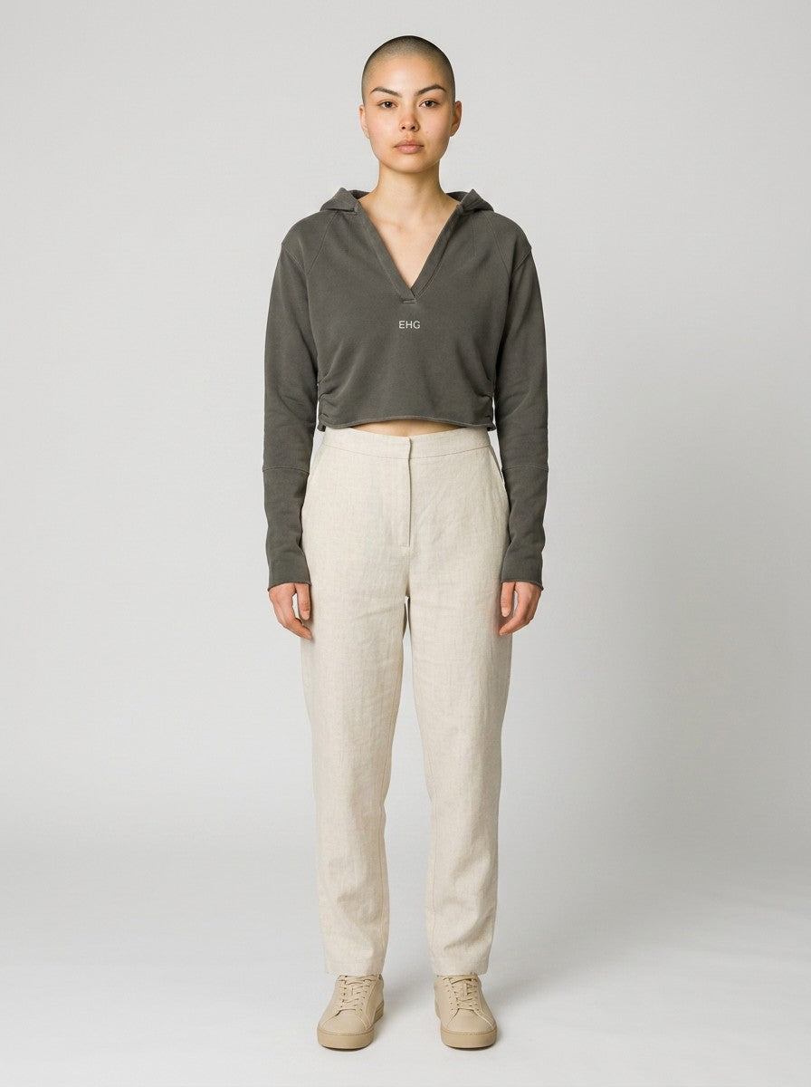EHG SmartWellness vintage washed dark grey cropped hoodie with raw edges and v-neck, worn by a model with beige trousers.