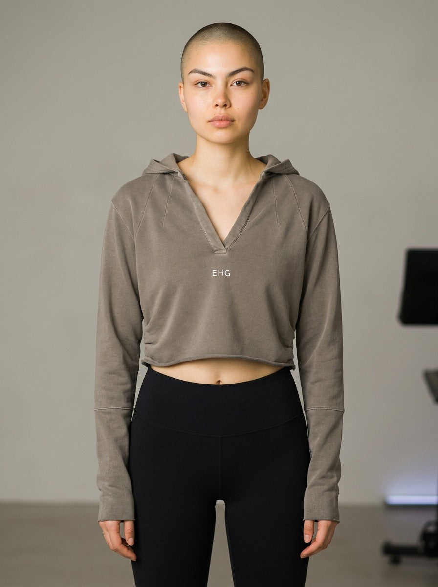 EHG SmartWellness vintage washed cropped hoodie in taupe with raw edges, v-neck, and long sleeves on a model.